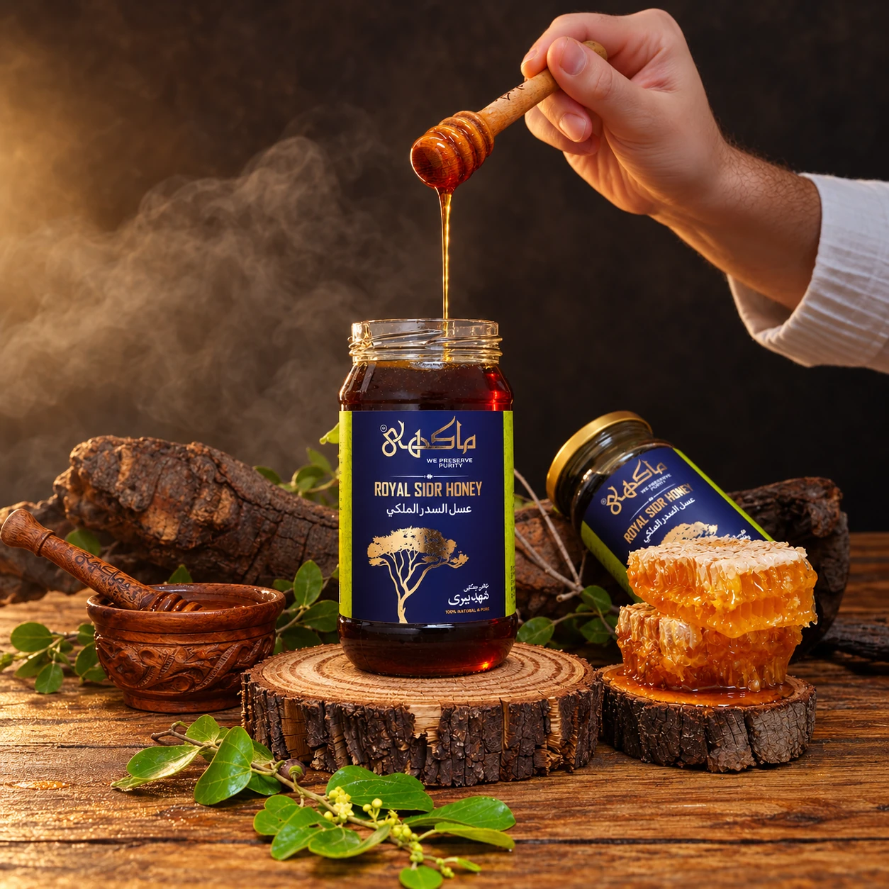 Golden honey pouring into a Maakhie Royal Sidr Honey jar beside honeycomb and a wooden bowl